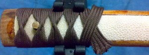 An example of a wrap in progress, showing the underlying ray skin (white) and ito (brown), with alternating twists. Image from www.sword-buyers-guide.com/Battle-Wrap.html.